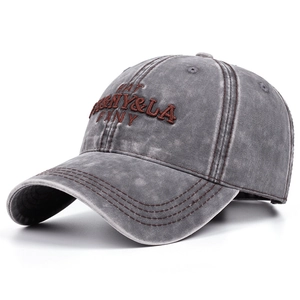 Detailed close-up of vintage washed denim baseball cap with red 3D letter embroidery