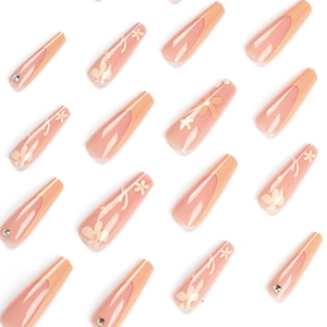 Long ballet press-on nails with orange French tips, white flowers and small rhinestones
