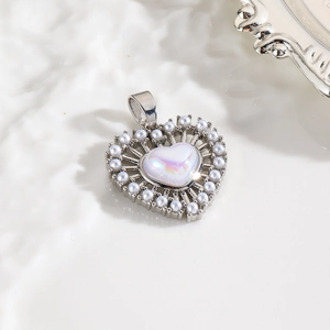 Macro shot of silver heart pendant with white pearls and iridescent center stone