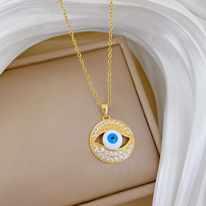 Close-up of golden Evil Eye necklace with blue-white center and sparkling crystals