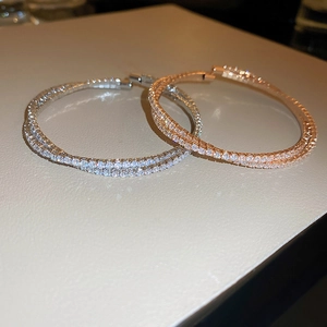 Detailed view of silver and rose gold hoop earrings with double-layered zircon pavé setting