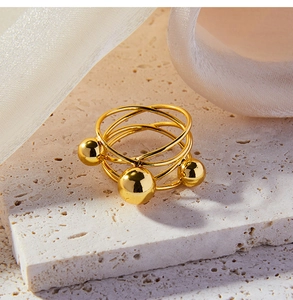 Detailed view of gold multi-layer wrap ring with spheres on a natural stone base