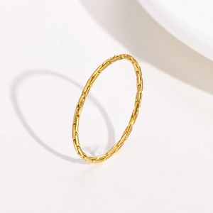 Golden stainless steel bamboo textured ring casting a romantic heart shaped shadow
