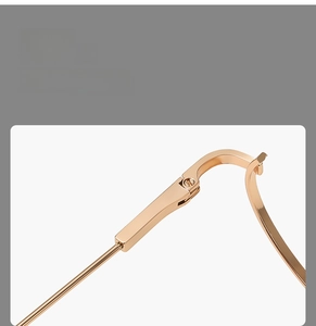Macro shot of rose gold half-frame glasses hinge and fine screw mechanism detail