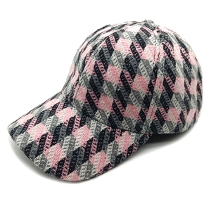 Detail of pink houndstooth tweed texture on a structured baseball cap with curved brim
