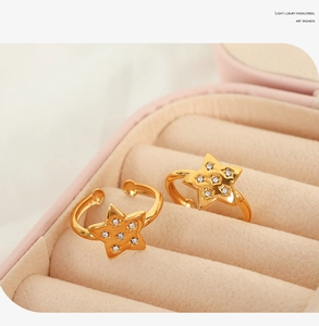 Detail of two gold-plated star rings with sparkling zircon pavé in a velvet jewelry box