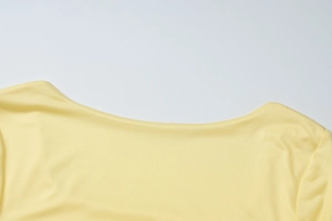 Vue détaillée du haut en maille jaune montrant l'encolure ronde côtelée et la texture du tissu