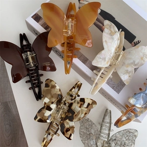 Close-up of butterfly acetate hair claws with elegant marble and tortoiseshell patterns