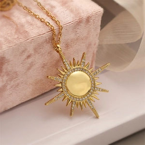 Golden sunburst pendant necklace with cubic zirconia, set on a pink velvet jewelry box