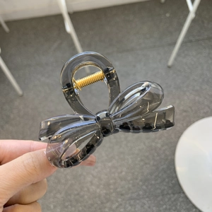 Detailed view of the elegant grey resin butterfly hair claw with a gold spring clip