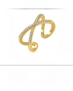 Detail of adjustable crisscross gold ring with white zircon and artificial gemstone