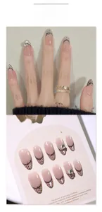 Close-up of French cat-eye press-on nails with black polka dots and lace bow accents