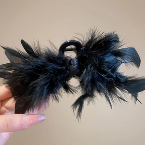 Detailed view of fluffy black feather hair claw clip with crystal acrylic accents