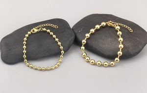 Detail of 18k gold plated beaded bracelets with lobster clasp and adjustable extension chain
