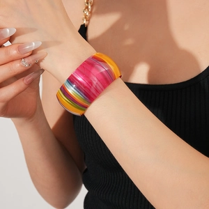 Detail of wide colorful striped acetate open bangle with vibrant translucent finish