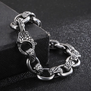 Detailed close-up of retro silver steel bracelet with totem patterns on a black surface