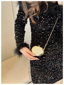 Detailed view of an octagonal gold metal mini bag with a fine chain strap and sequins