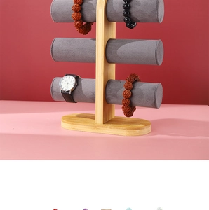 Three-tier bamboo jewelry stand with grey velvet cylinders for watches and bracelets
