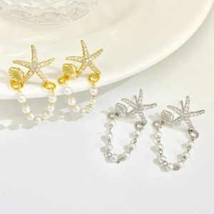 Detail of starfish tassel earrings with rhinestones and faux pearls in gold and silver