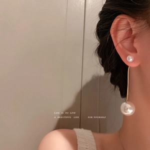 Élégantes boucles d'oreilles pendantes en perles et chaîne serpent dorée sur mannequin