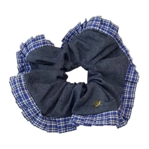 Blue denim and plaid scrunchie hair tie with gold button detail on white background