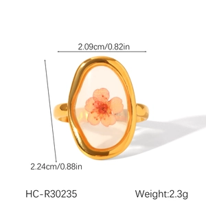 Detail showing dimensions of the gold stainless steel ring with a pink dried flower
