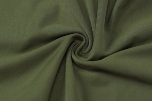 Close-up of olive green ribbed knit fabric texture and elegant pleated details on dress