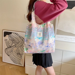 Borsa tote in tela floreale nei colori macaron indossata da una modella in casa