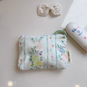 Detailed view of floral cotton mini pouch with zipper and green woven pull cord