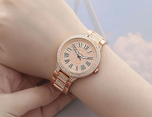 Close-up of rose gold women's watch with Roman numerals and sparkling crystals