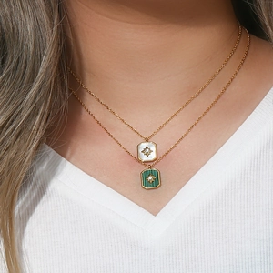 Close-up of double-layer gold necklaces with white and green square shell star pendants