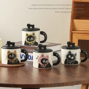 Set of four cute ceramic cat mugs with lids in various colors on a wooden table