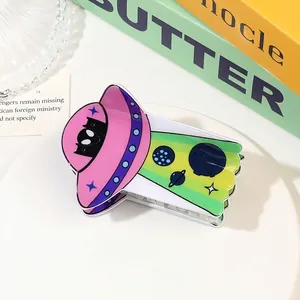 Detail of UFO-shaped hair claw clip with colorful gradient design and cute alien cat motif