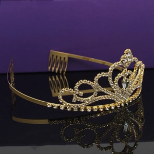 Detail of a golden crown with white rhinestones and anti-slip hair comb on purple background