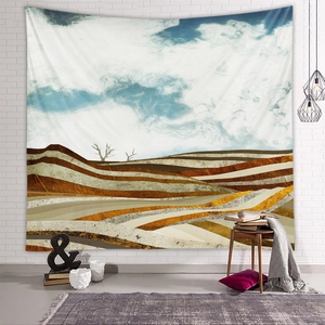 Detailed view of an abstract mountain tapestry hanging on a white brick wall in a cozy room