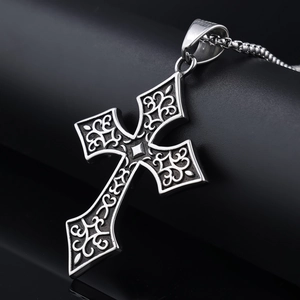 Detailed close-up of vintage silver Viking cross pendant with gothic relief patterns