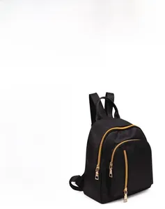 Detail of a black waterproof nylon backpack featuring premium gold metal zippers and pockets