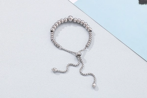 Detail of silver beaded bracelet featuring adjustable slider clasp and polished spheres
