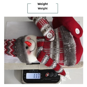 Detail shot showing a 117g plush Christmas snowman decoration on a digital scale