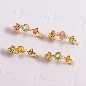 Detail of flower rings with colorful oval zircons and gold plating in 2x2 grid view