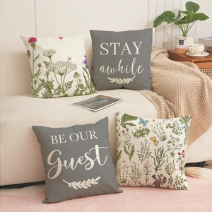 Floral pattern and letter printed square cushion covers on a beige sofa in a cozy setting