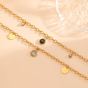 Macro shot of gold-plated chain bracelet with opal pendant and crystal accents
