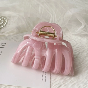 Detail of pink ink-wash large hair claw clip with golden spring on elegant props