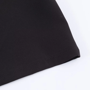 Détail rapproché de la texture du tissu noir et de la couture sur le haut polo