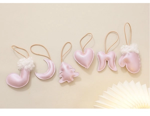 Detail of pearlescent pink leather Christmas tree ornaments in various festive shapes