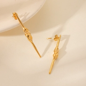 Minimalist gold spiral twist stainless steel stud earrings on a cream background