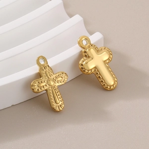 Detailed macro view of gold cross pendants featuring embossed dots and rope edge textures