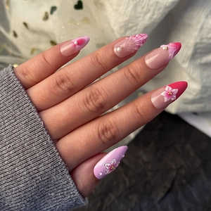 Rosa-violette Mandel-Kunstnägel mit 3D-Blumenakzenten und eleganten Perlenverzierungen
