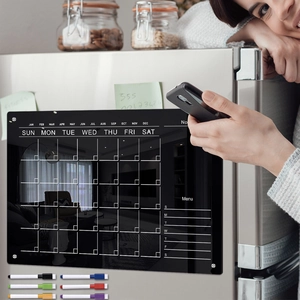 Detailed view of black magnetic acrylic weekly planner on a stainless steel fridge