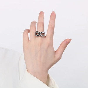 Close-up of a silver infinity symbol ring made of titanium steel on a finger